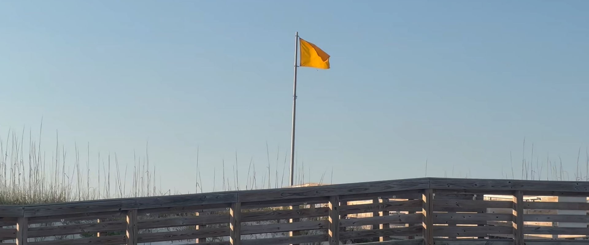 yellow flag on navarre beach boardwalk
